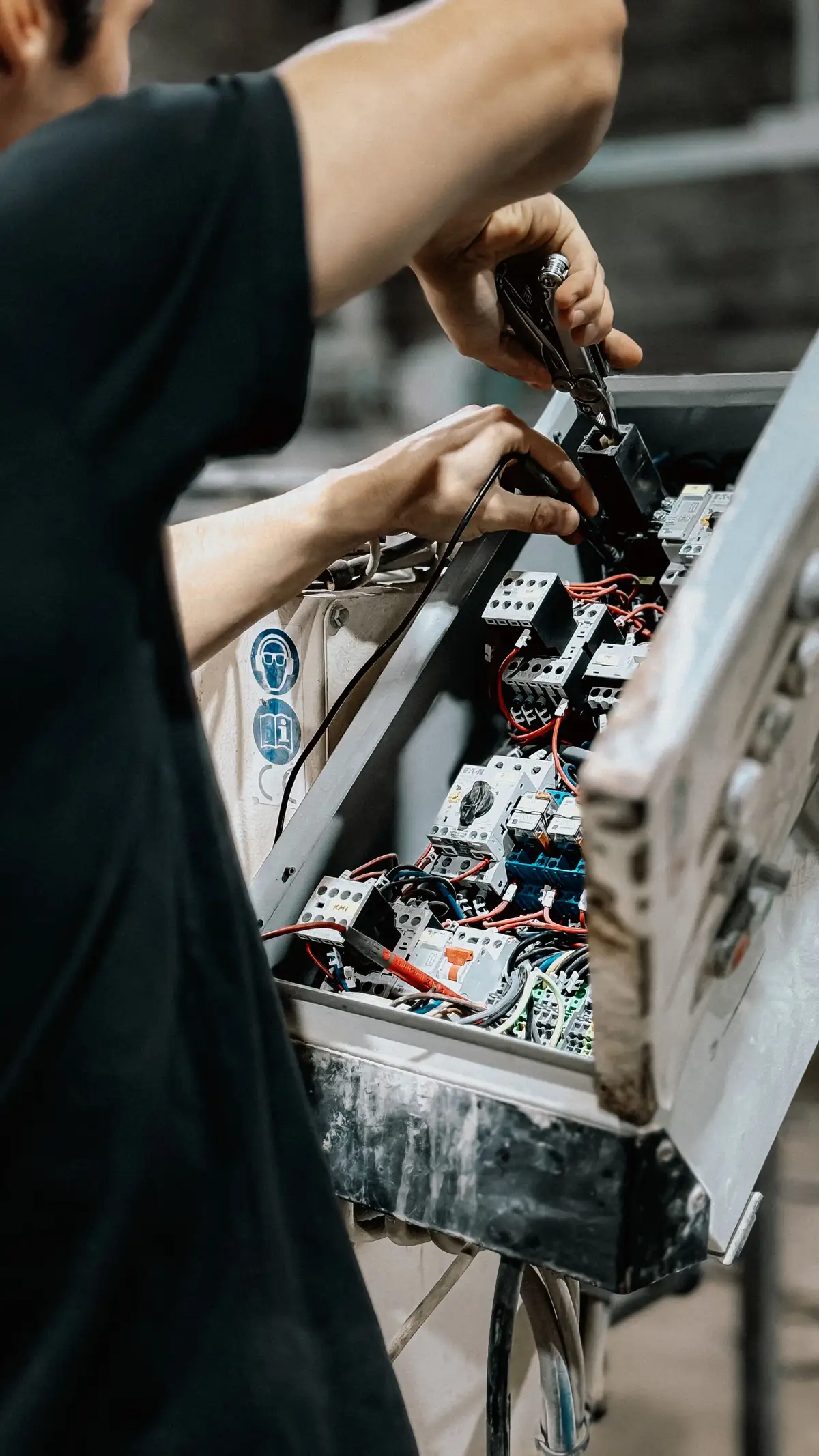 Intervention dans une armoire électrique industrielle ouverte