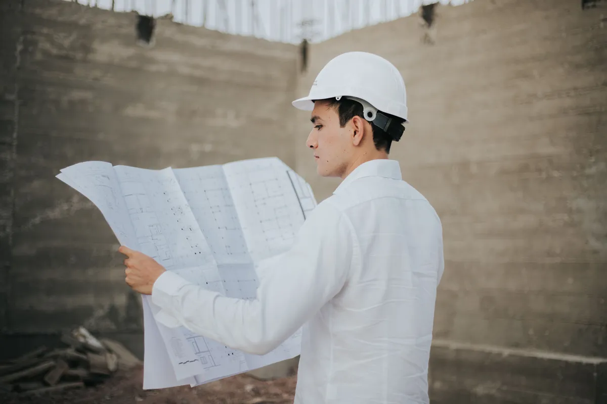 Conducteur de travaux en casque de chantier consultant un plan