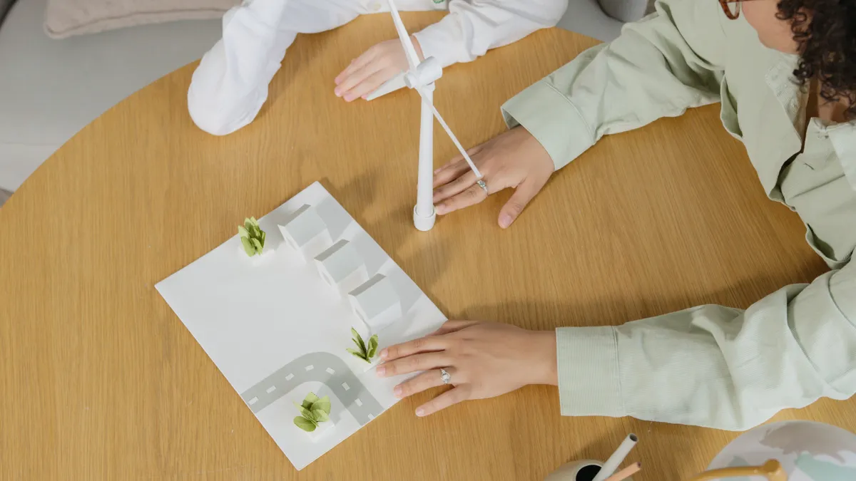 Maquette de bâtiment avec éolienne miniature, présentée sur une table